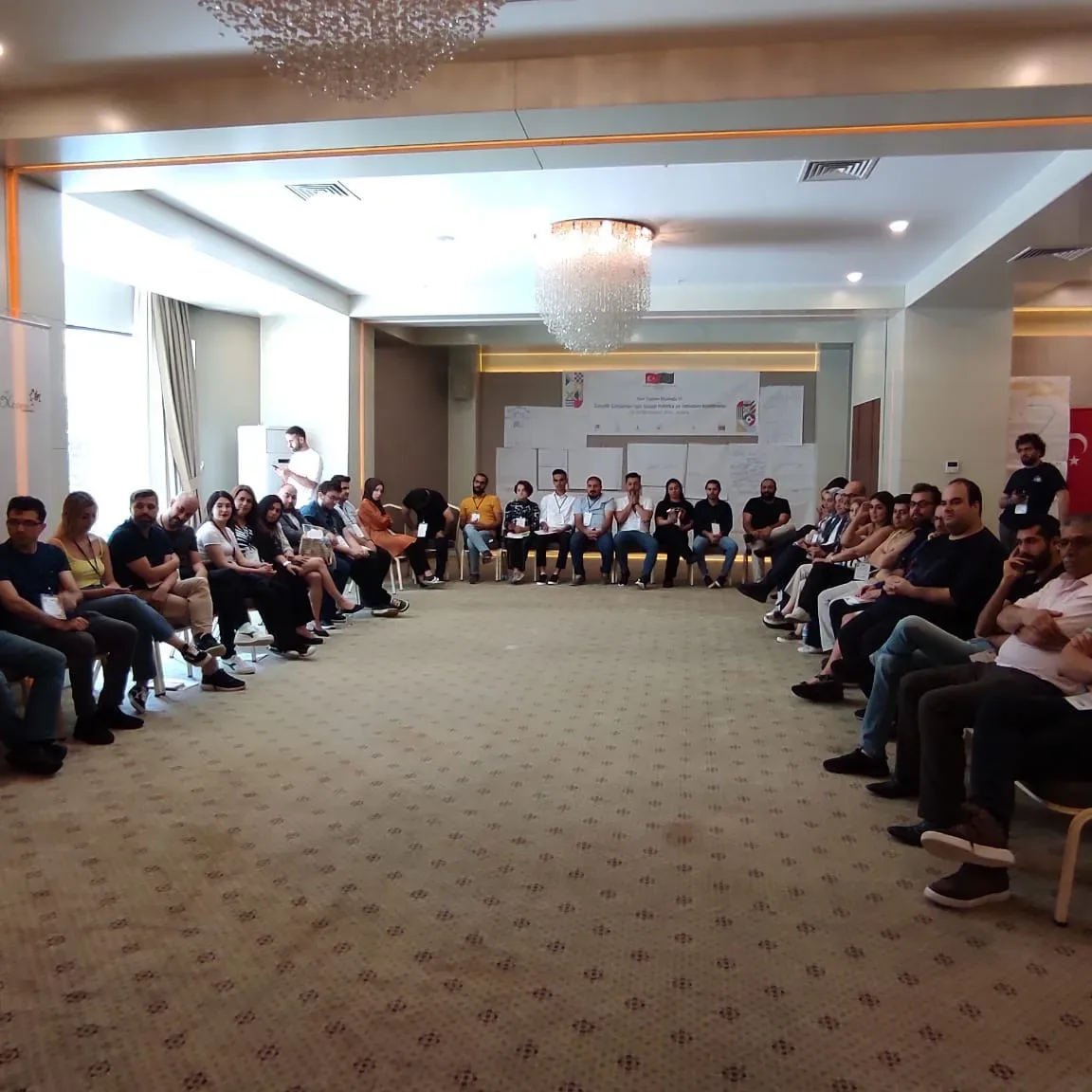 Youth workers seated in a large circle in the conference room