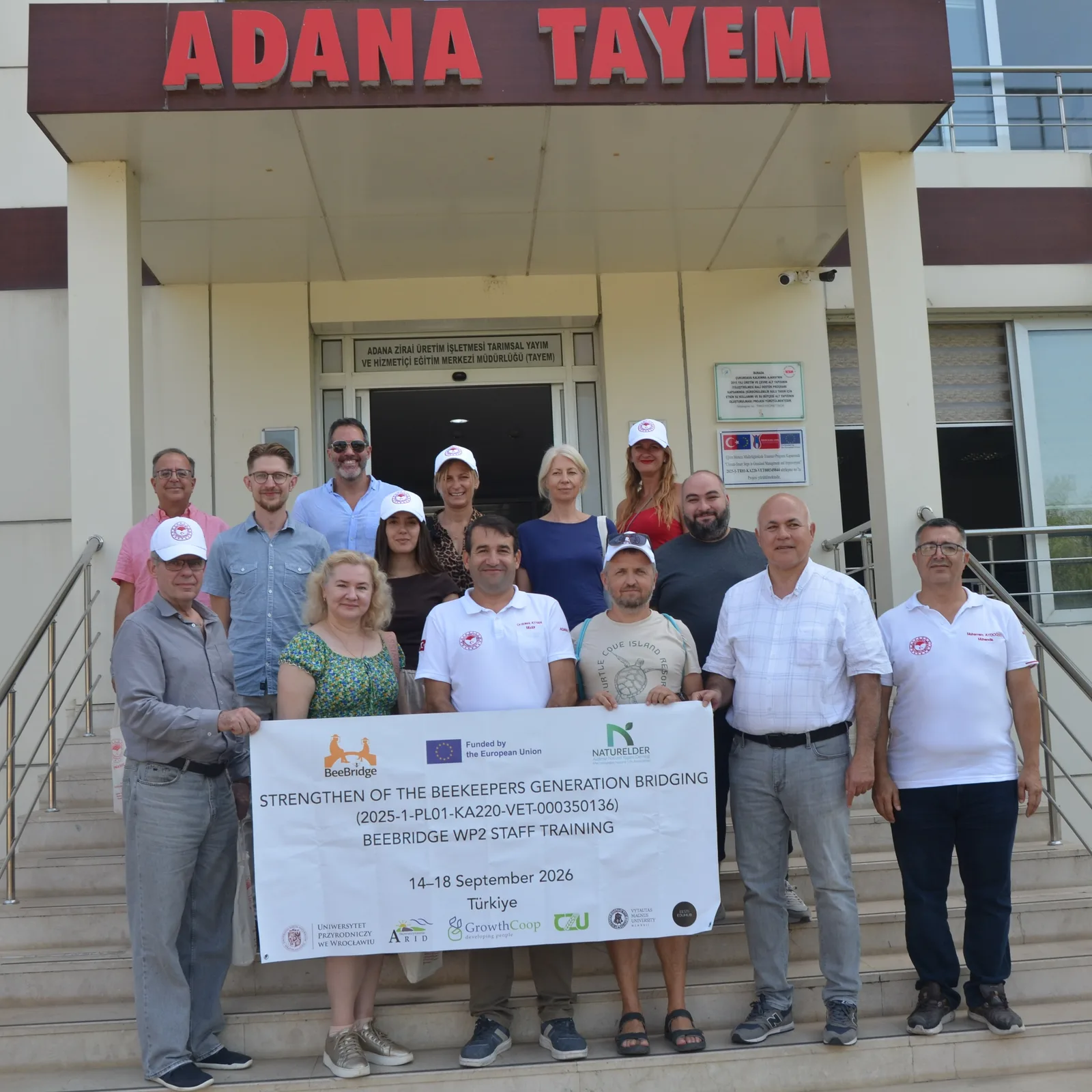 BeeBridge participants and local hosts with the project banner outside Adana TAYEM