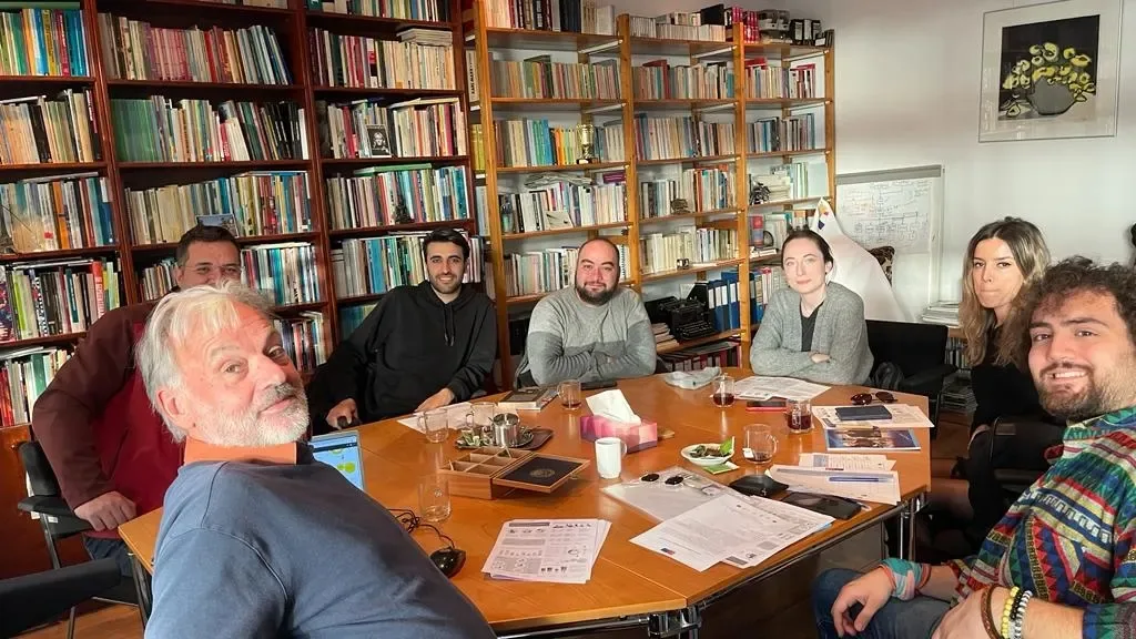 Participants gathered around a table in a room lined with bookshelves during an NGO visit in the Netherlands